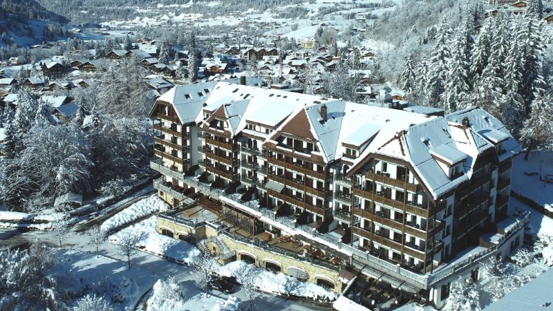 Exterior view of The Park Gstaad hotel in Switzerland, set against the Swiss Alps, ahead of its reopening as a Four Seasons hotel in winter 2026–27